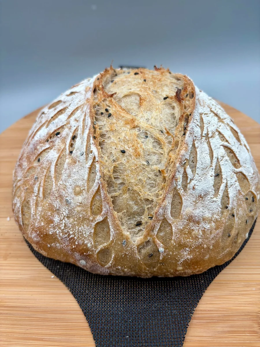 Henry’s golden loaf with flour-dusted scoring on a wooden board